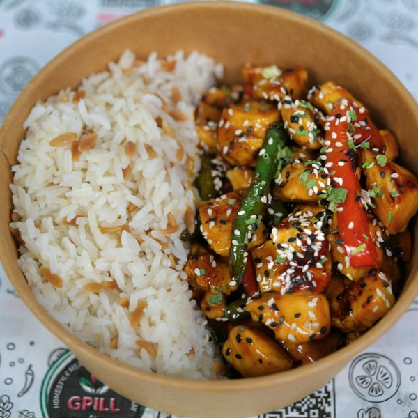 A close-up of a takeout bowl with white rice and sesame chicken with peppers and green beans.